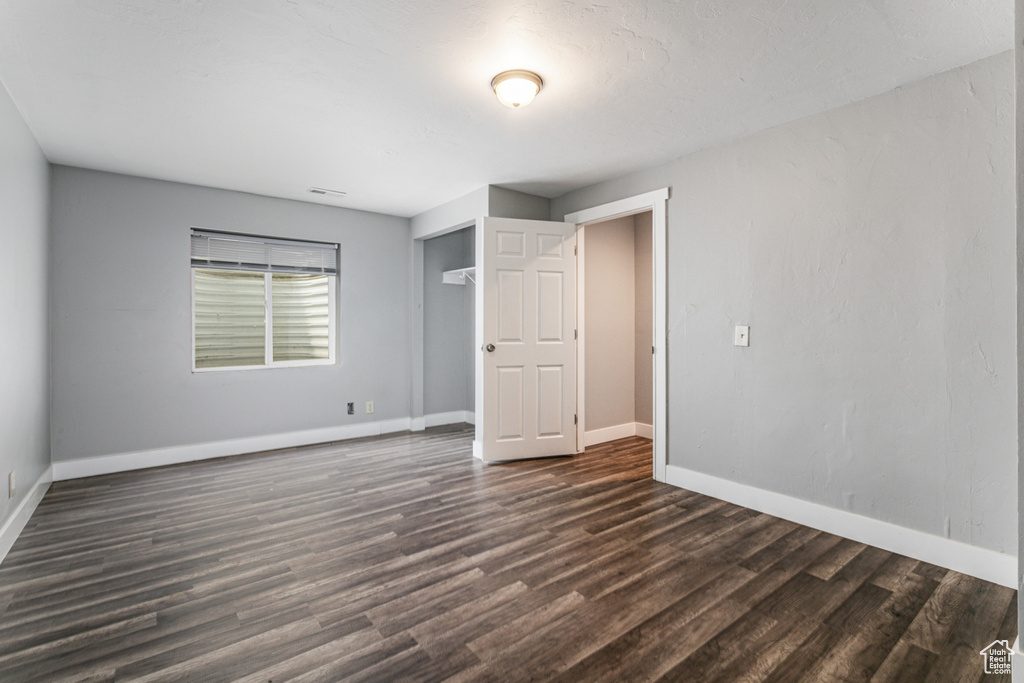 Unfurnished bedroom with dark wood-type flooring