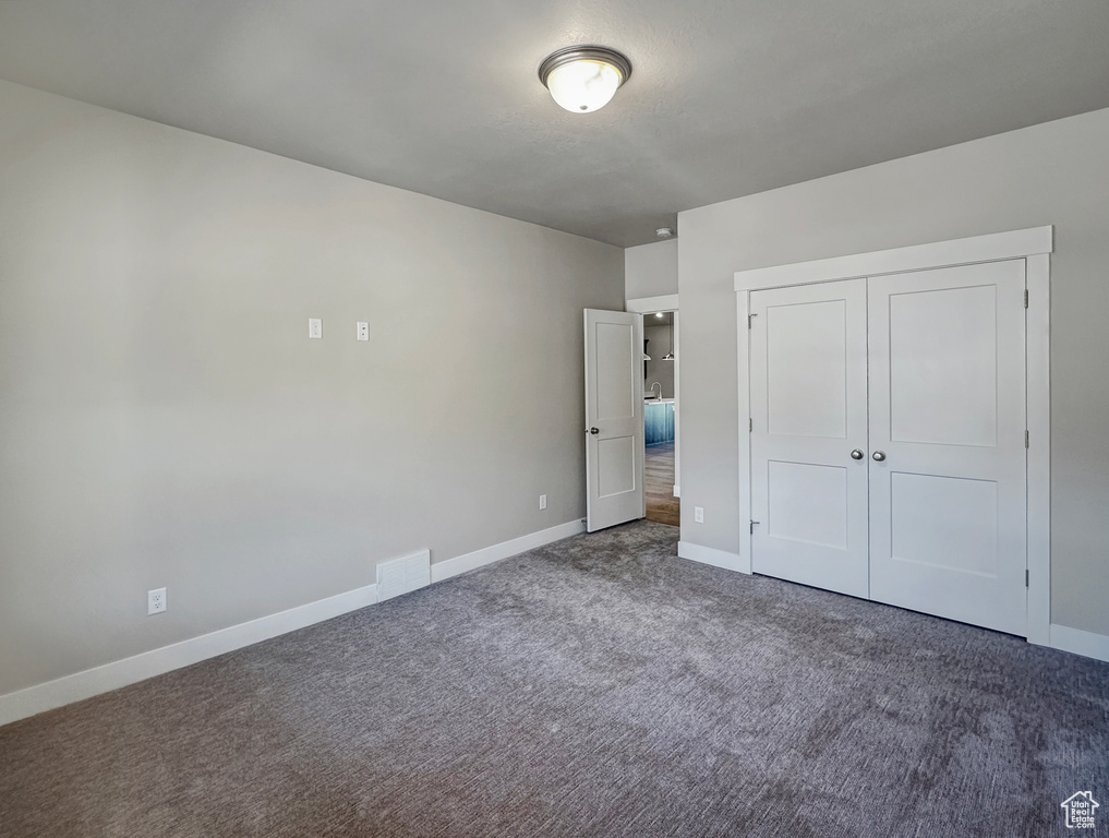 Unfurnished bedroom featuring a closet and carpet flooring