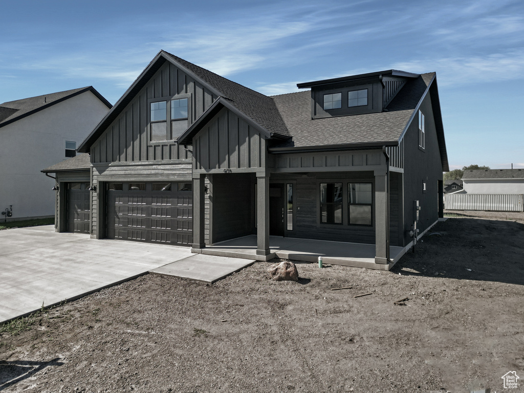 View of front of property featuring covered porch and a garage