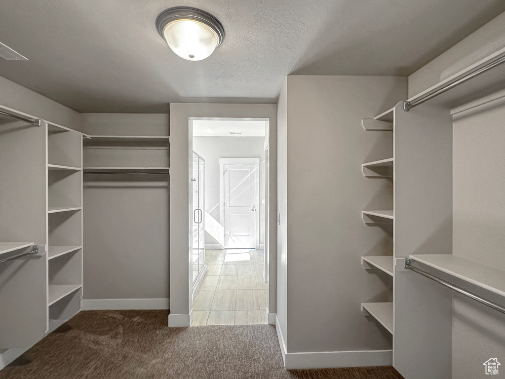 Walk in closet featuring dark carpet