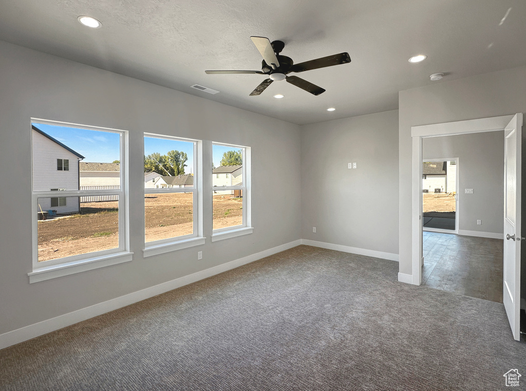 Carpeted spare room with ceiling fan