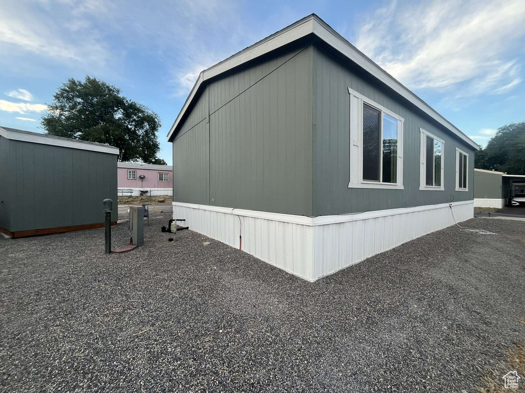 View of side of home featuring an outbuilding