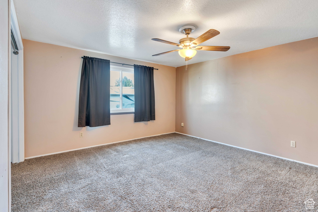 Spare room with carpet floors, a textured ceiling, and ceiling fan