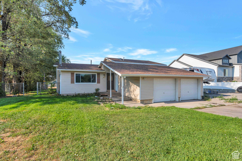 View of front of house with a garage and a front lawn