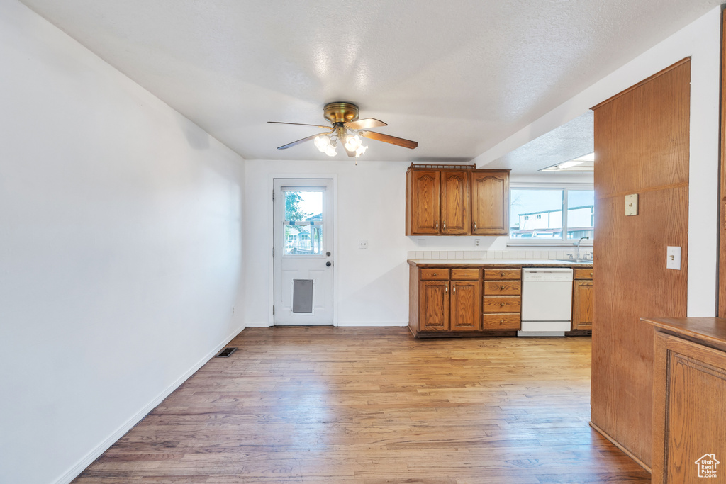 Kitchen featuring sink, light hardwood / wood-style flooring, white dishwasher, and ceiling fan