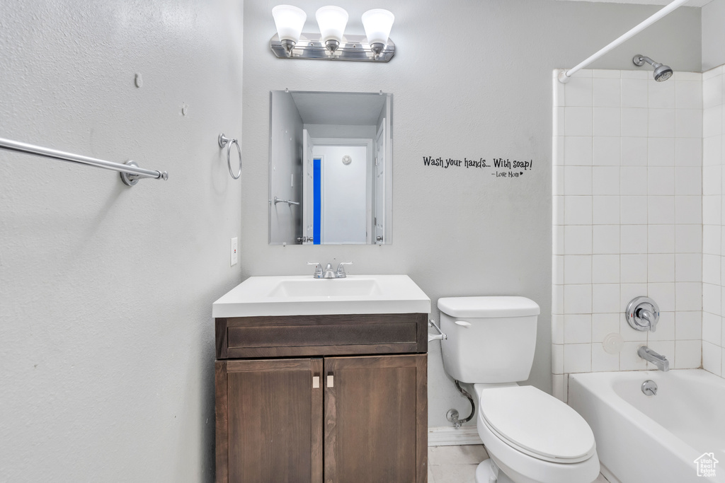 Full bathroom with vanity, toilet, tile patterned floors, and tiled shower / bath