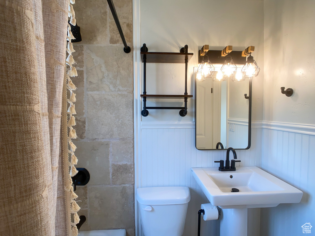 Bathroom featuring toilet and shower / tub combo with curtain