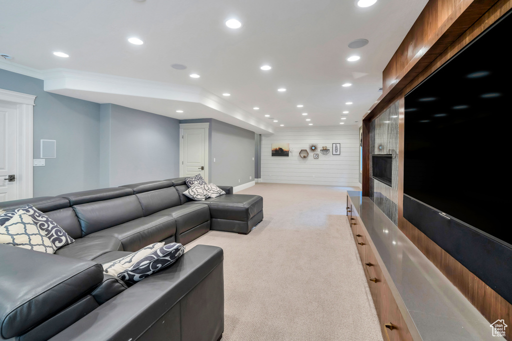 Carpeted home theater room featuring crown molding