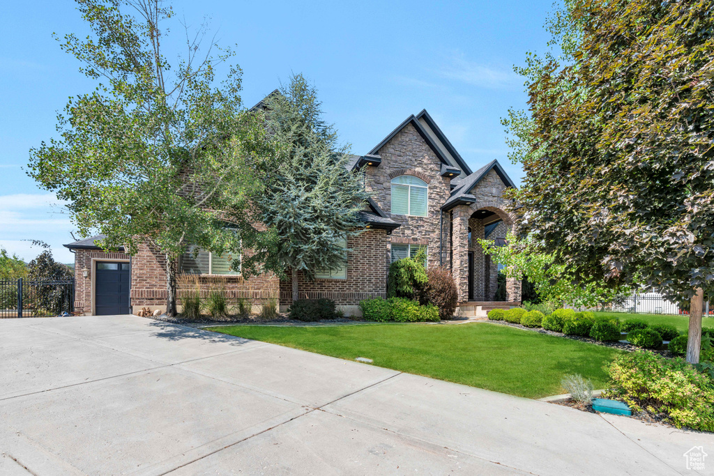 View of front of house with a garage and a front lawn