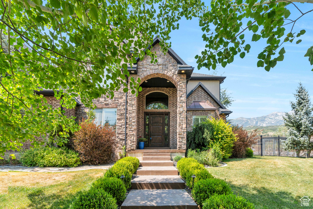 View of front of house featuring a mountain view and a front yard