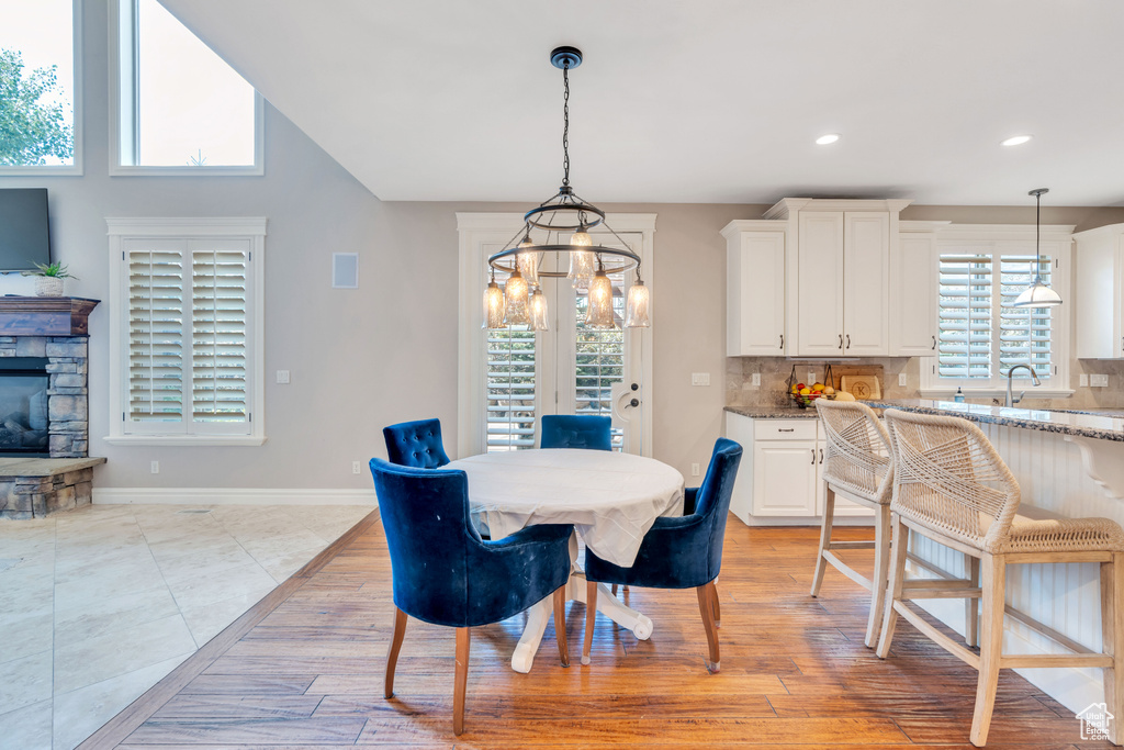 Dining room with a chandelier, light tile patterned floors, and a wealth of natural light