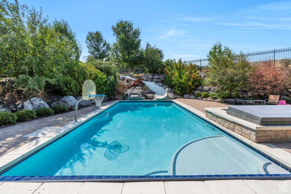 View of swimming pool featuring a water slide and a patio