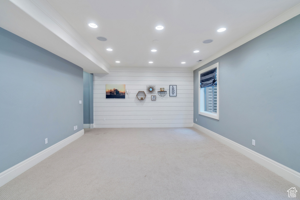 Unfurnished living room featuring light carpet and ornamental molding