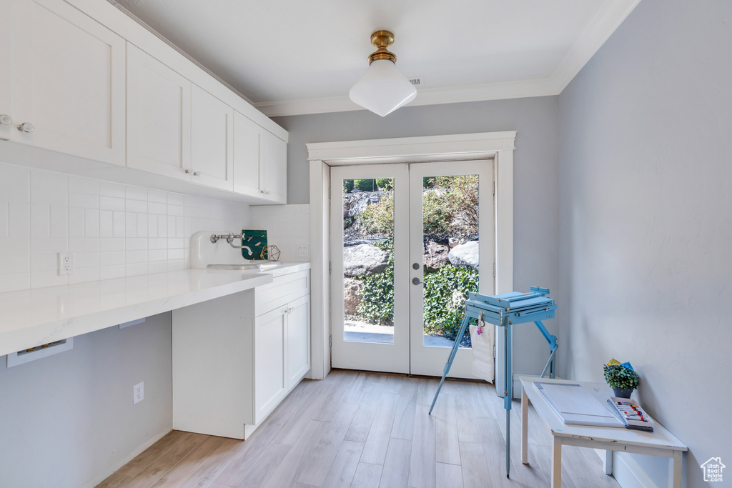 Interior space with backsplash, light hardwood / wood-style floors, french doors, and a wealth of natural light