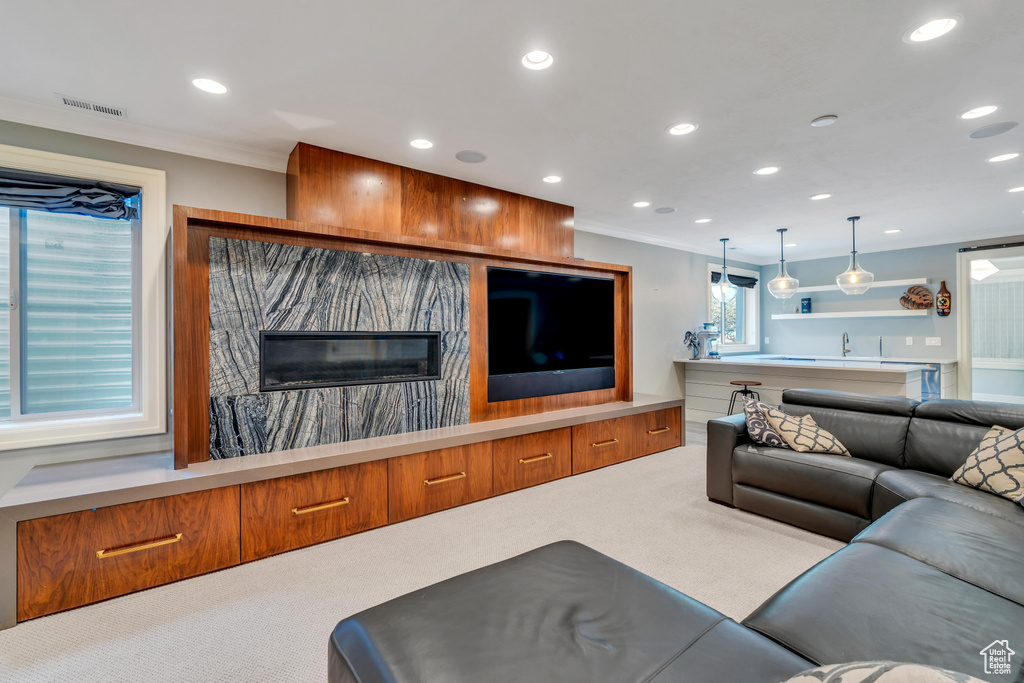 Living room featuring carpet floors, sink, and ornamental molding