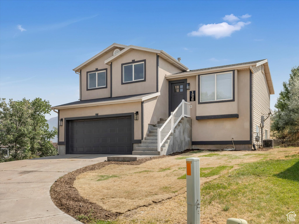 View of front of property with a garage and a front lawn