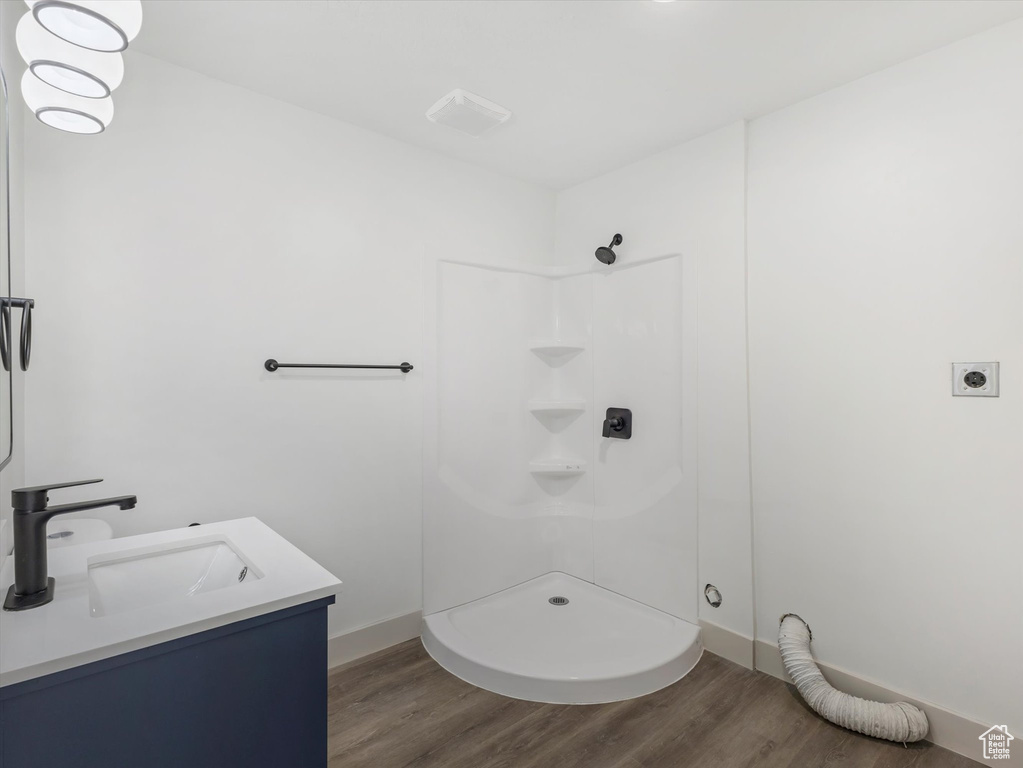 Bathroom featuring vanity, wood-type flooring, and walk in shower