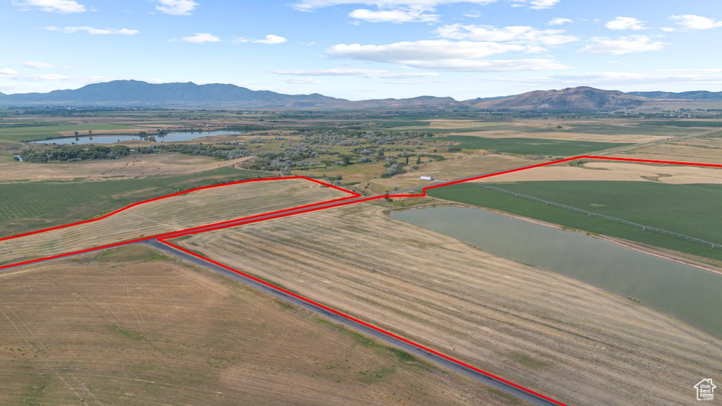 Drone / aerial view with a water and mountain view and a rural view