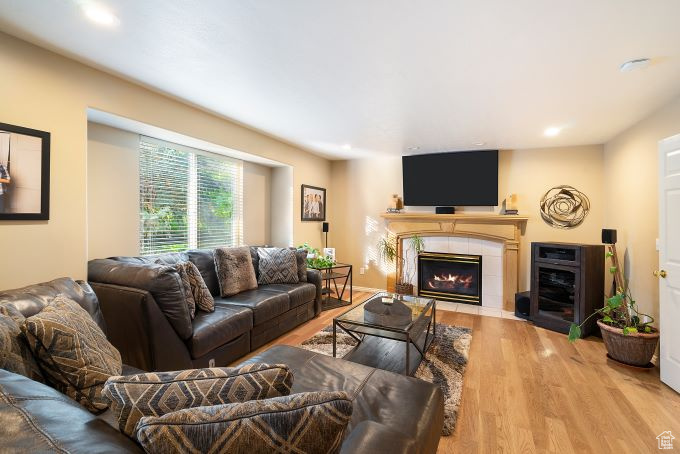 Living room featuring wood-type flooring and a tiled fireplace