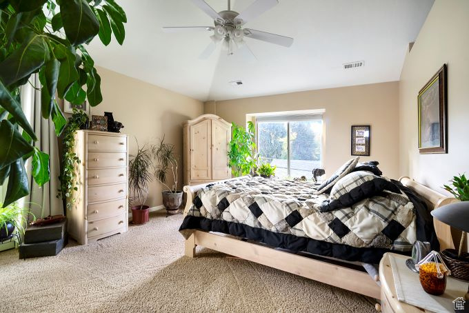 Bedroom featuring carpet flooring, vaulted ceiling, and ceiling fan