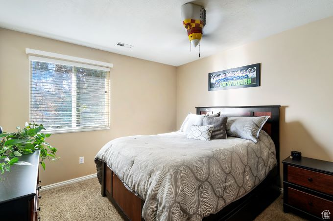 Carpeted bedroom featuring ceiling fan