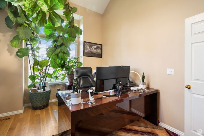 Office featuring hardwood / wood-style flooring and lofted ceiling