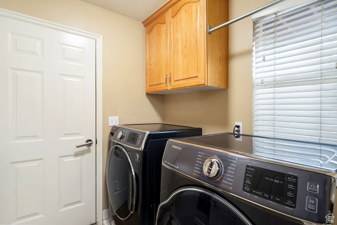 Laundry room with cabinets and washing machine and clothes dryer