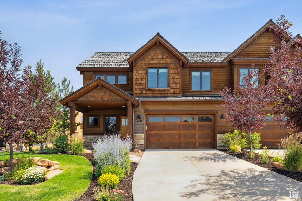 View of front of home with a garage and a front lawn