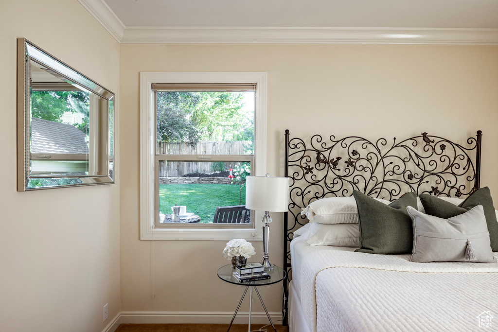 Bedroom with ornamental molding and multiple windows