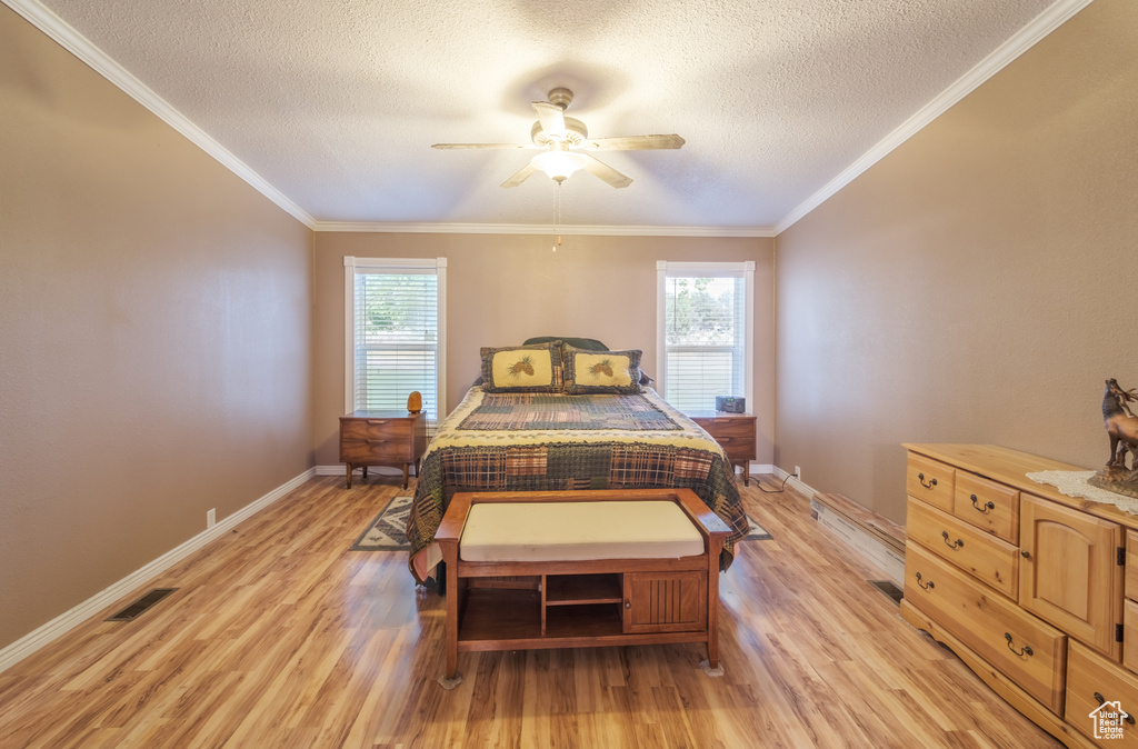 Bedroom with crown molding, multiple windows, light wood-type flooring, and ceiling fan