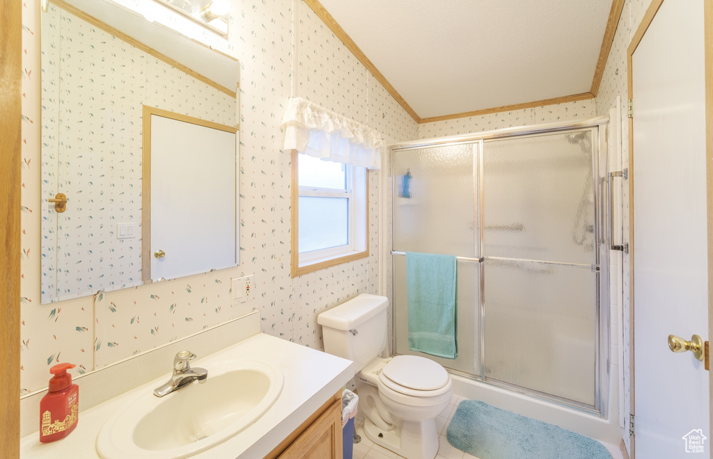 Bathroom with a shower with door, crown molding, toilet, vanity, and vaulted ceiling