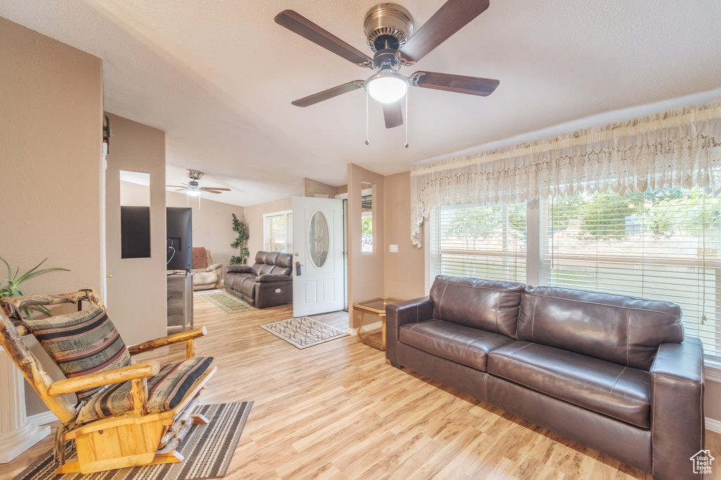 Living room with light hardwood / wood-style floors and ceiling fan