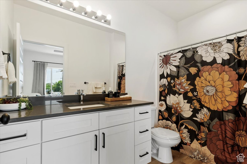 Bathroom with hardwood / wood-style floors, vanity, and toilet