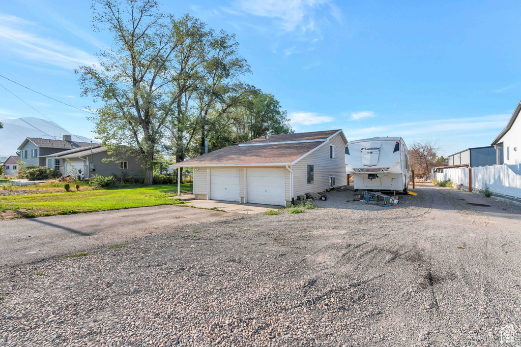 View of side of home with a garage and a lawn