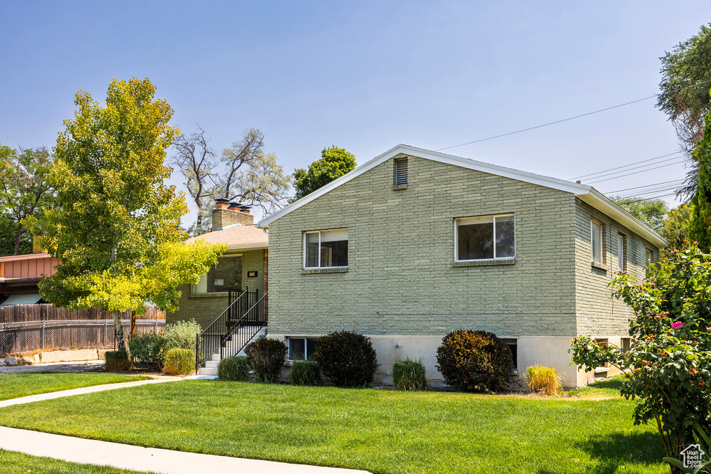 View of side of home with a lawn