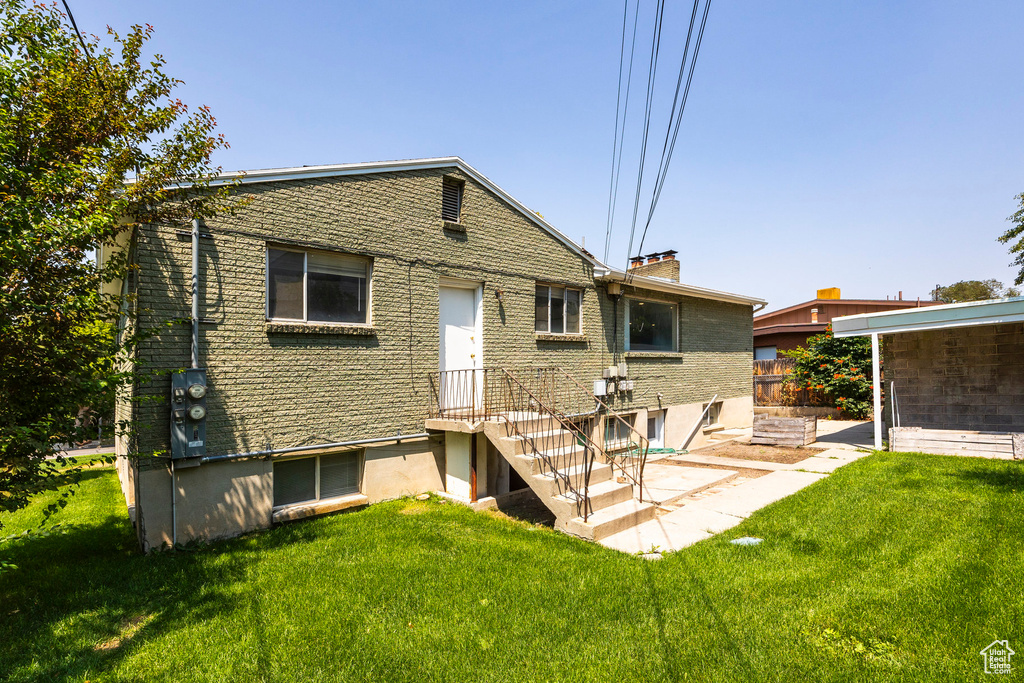 Rear view of house with a patio and a yard