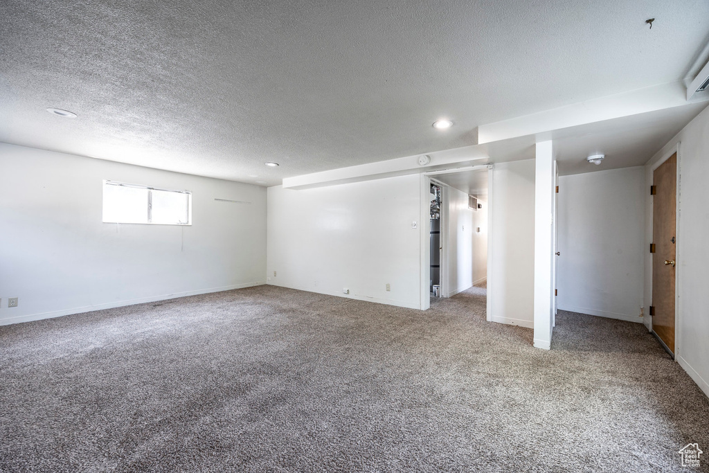 Unfurnished bedroom with a textured ceiling and light colored carpet