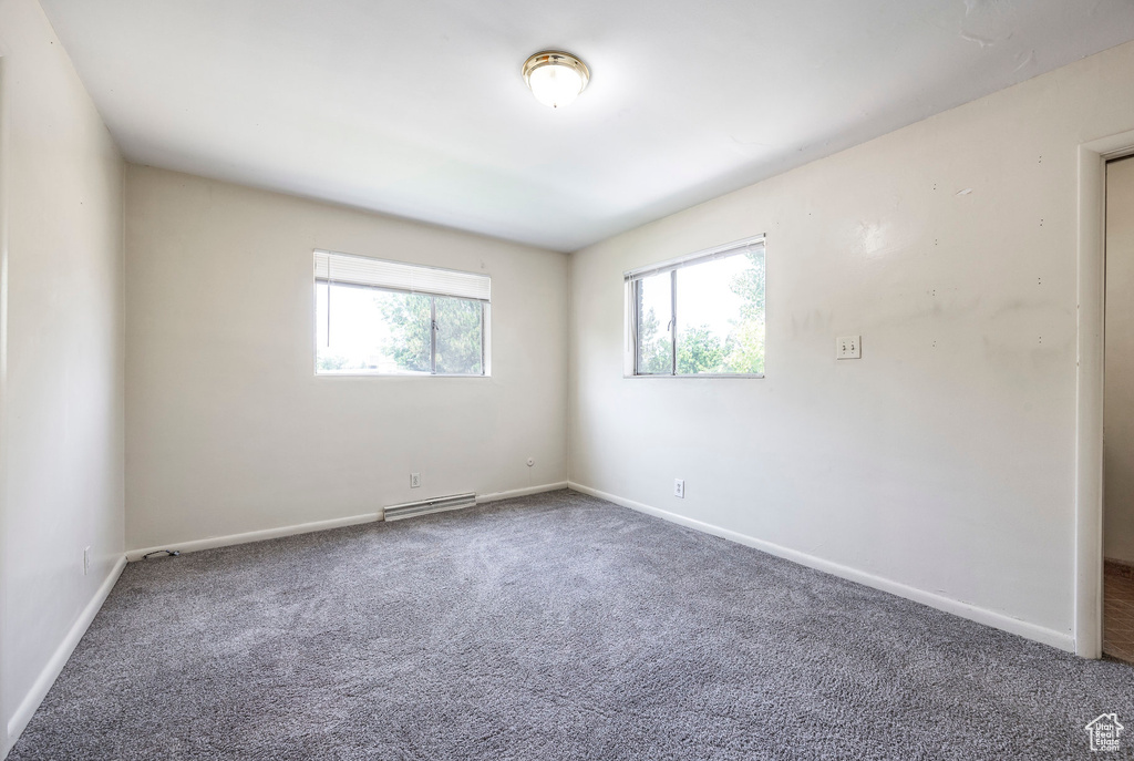 Carpeted spare room with a baseboard radiator