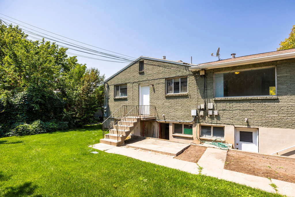 Rear view of property featuring a yard