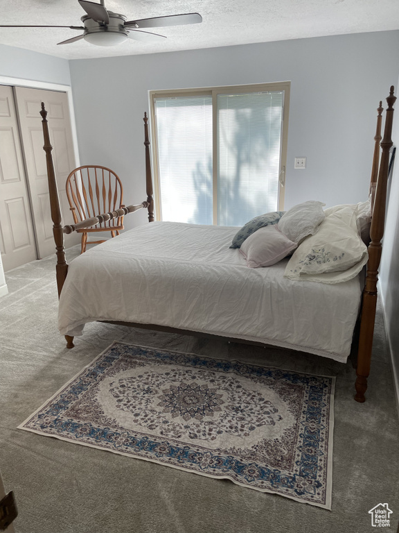 Bedroom featuring a closet, carpet, a textured ceiling, and ceiling fan