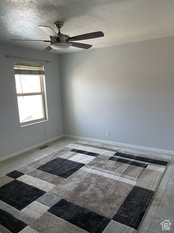 Spare room with a textured ceiling and ceiling fan