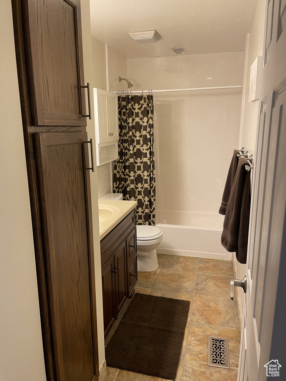 Full bathroom with tile patterned flooring, toilet, vanity, and shower / tub combo with curtain