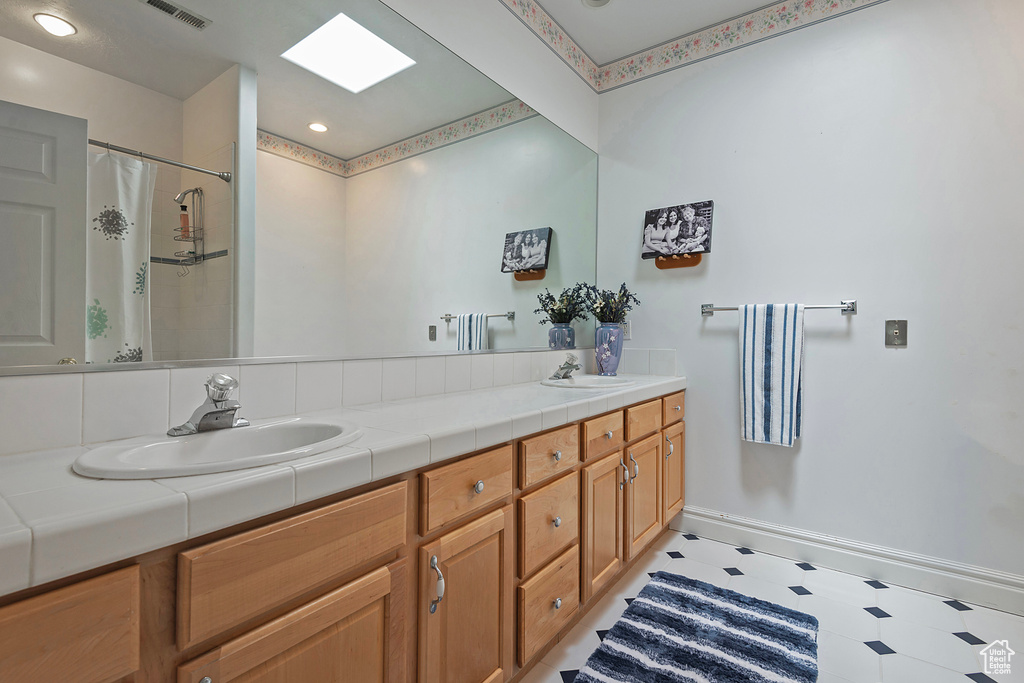 Bathroom with tile patterned flooring and double sink vanity