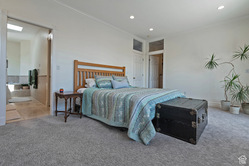 Carpeted bedroom with ensuite bathroom and crown molding