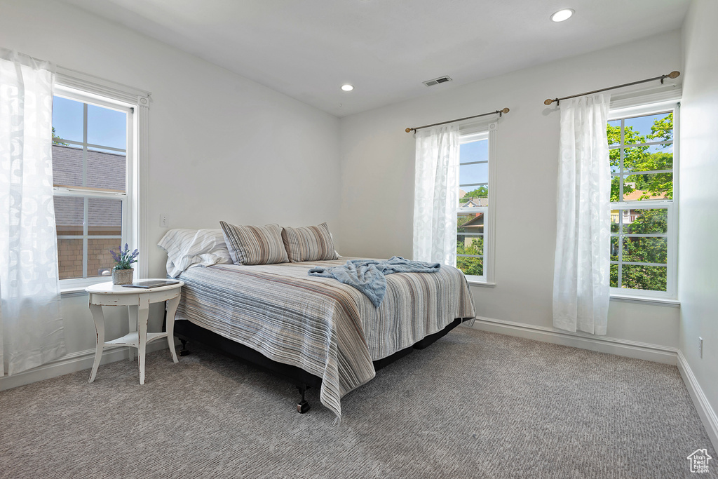 Bedroom with multiple windows and carpet flooring