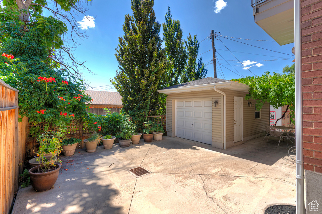 View of patio / terrace featuring a garage and an outbuilding