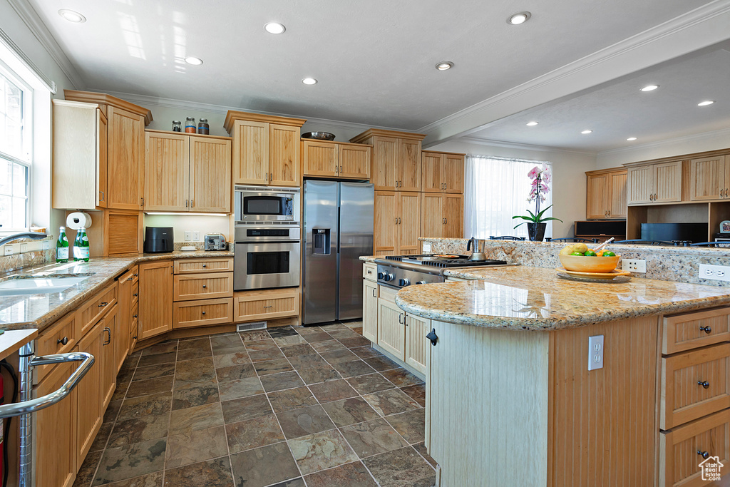 Kitchen featuring a healthy amount of sunlight, dark tile patterned flooring, appliances with stainless steel finishes, and sink