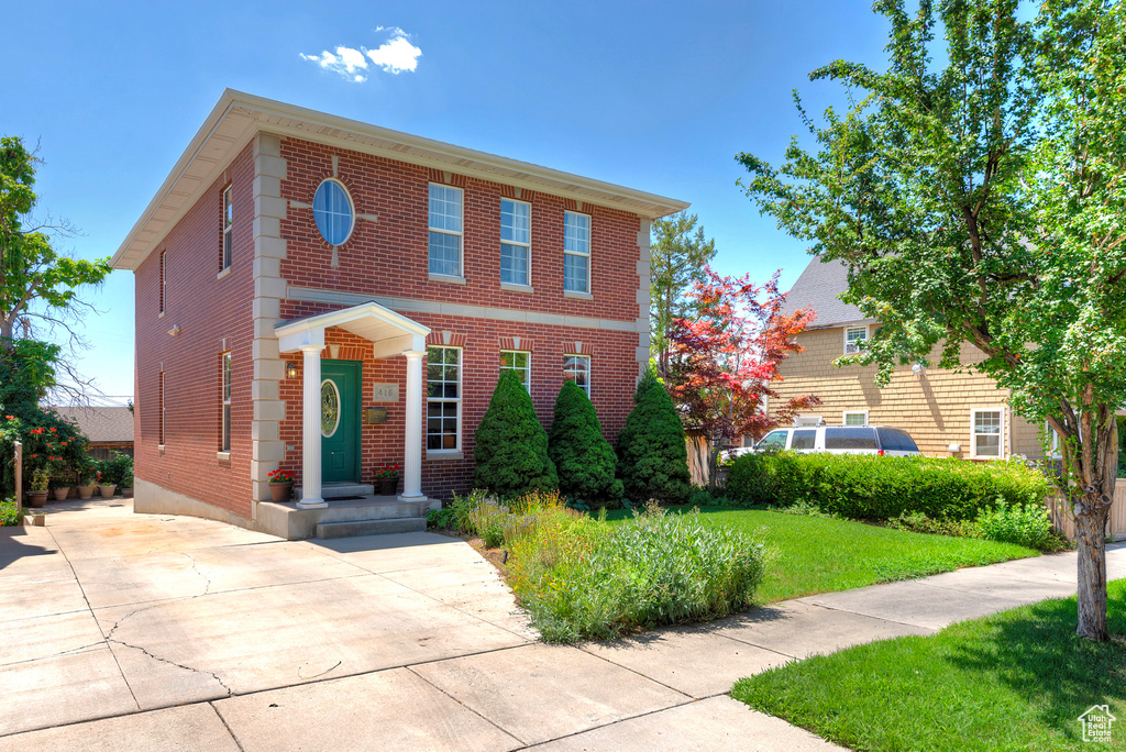 Colonial-style house featuring a front lawn