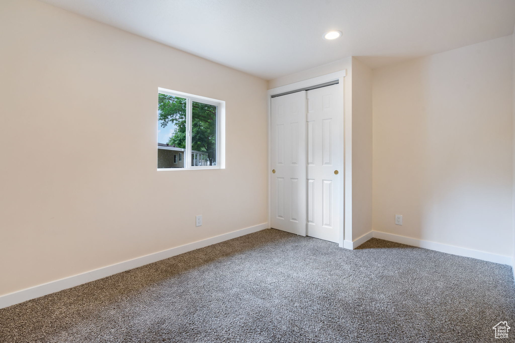 Unfurnished bedroom with carpet and a closet