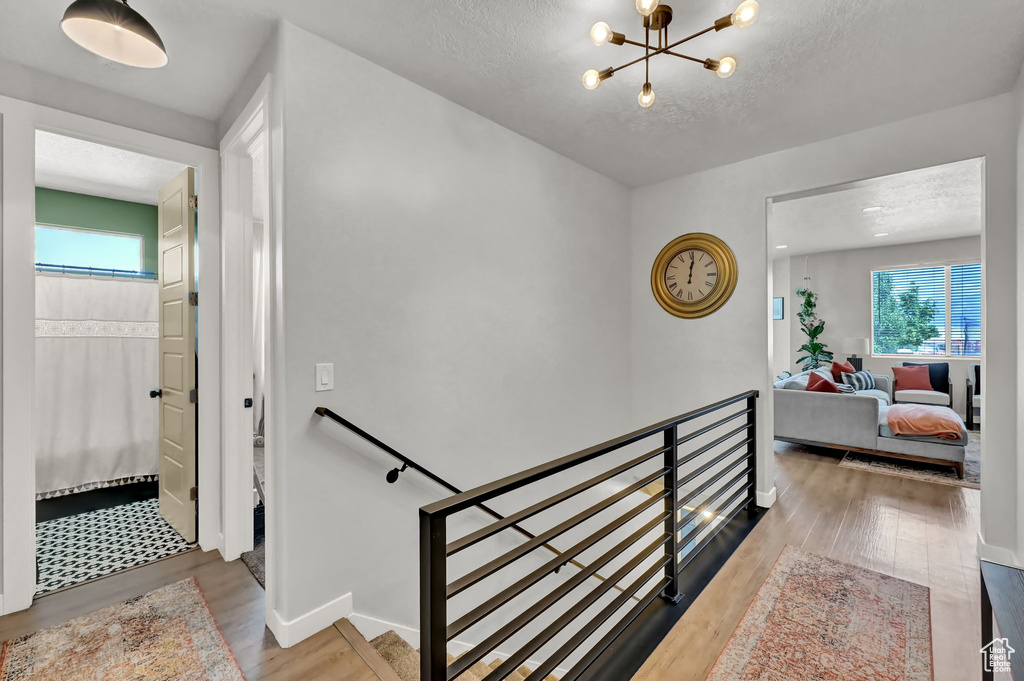 Interior space with a notable chandelier, light wood-type flooring, and a textured ceiling